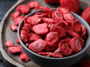 Strawberry pieces in a black bowl.