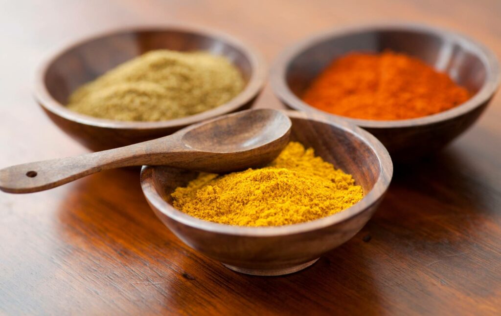 Wooden bowl filled with 3 different freeze-dried vegetable powders