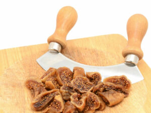 Dried pieces of fig beside a knife