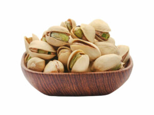 Shelled pistachios in a wooden bowl.