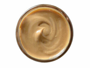 Top view of brown peanut paste in a jar.
