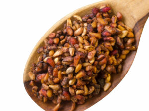 Dried pomogranate seeds on a wooden spoon.