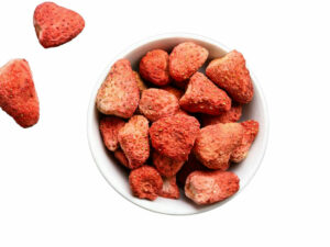 Top view of dried, whole strawberries in a bowl.