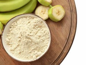Top view of a white flour beside a bunch of green bananas