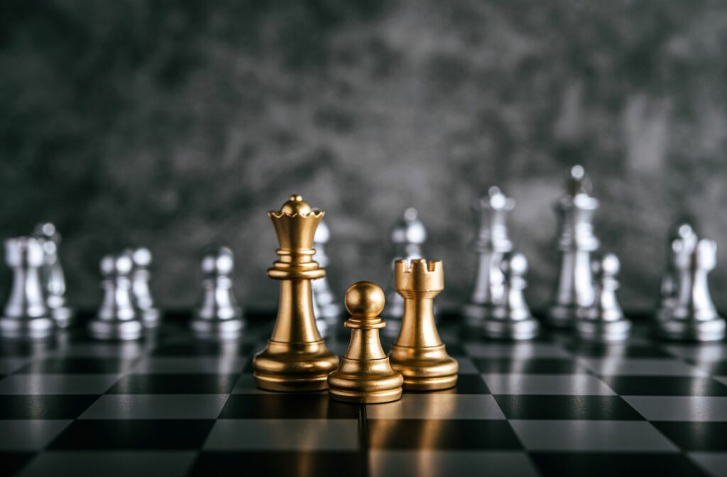 gold and silver chess pieces on a chess board