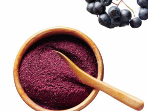 Top view of dark purple powder in a bowl with a spoon.