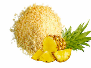 Yellow Pineapple granules in a heap, displayed with a whole pineapple.