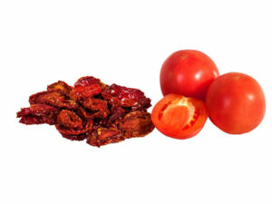 Sun-Dried tomatoes displayed beside two fresh tomatoes.