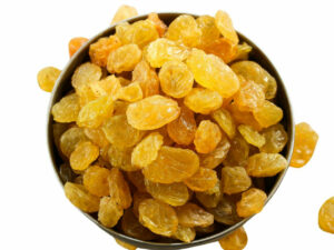 Top view of golden Rasins, heaped in a bowl.