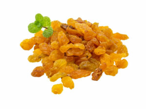 dried, golden grapes in a heap, displayed with a leaf.