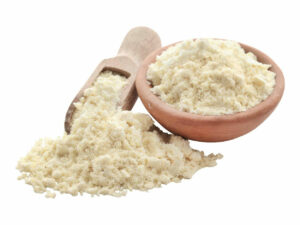 Pale-yellow powder in a bowl beside a heap of the same powder.