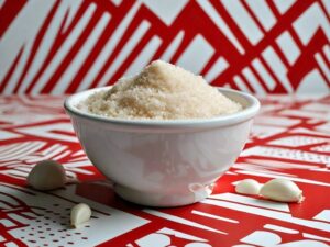 Garlic powder on a white bowl with a red and white pop art background
