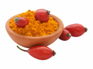 Vibrant orange powder in a bowl displayed with red rosehip fruit.