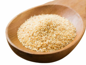 light brown/ beige granules displayed on a wooden spoon.