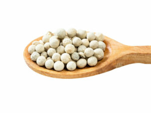 White seeds displayed on a wooden spoon.