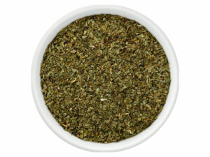 Top view of dried, green herbs in a bowl.