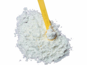 Top view of a fine white powder, displayed with a yellow measuring spoon.