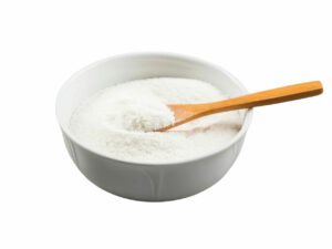 White powder in a bowl displayed with a wooden spoon.