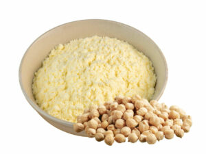 Yellow white powder in a bowl, displayed beside some soy beans.
