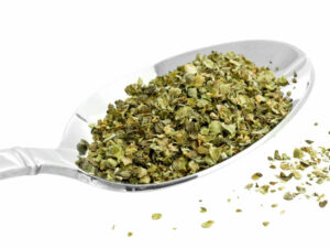 Dried, green herbs on a spoon.