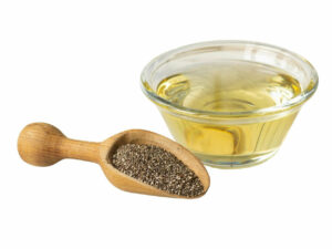 Oil in a transparent bowl beside a bowl beside a scoop of chia seeds,
