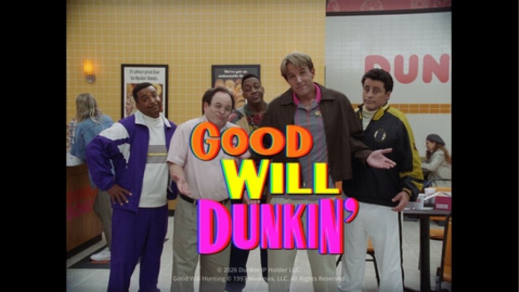 A screenshot from the "Good Will Dunkin'" commercial showing Ben Affleck in a Dunkin' uniform standing next to Matt LeBlanc and Jason Alexander in a 90s sitcom set.