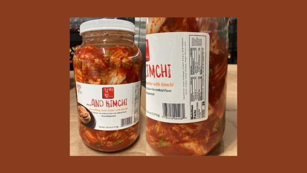 The front of a 126 oz clear plastic jar of '...And Kimchi' branded sliced kimchi with a red logo, recalled by Ocinet Inc. due to undeclared fish