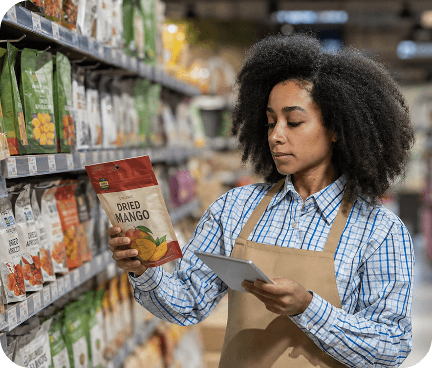 Team member checking product details in a grocery aisle